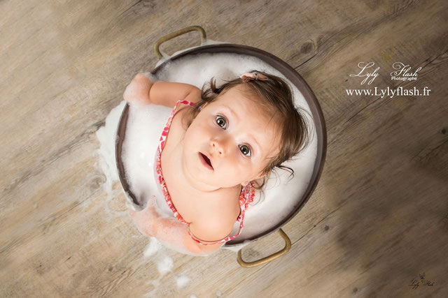 une belle petite fille d'un an prend un bain apres sa séance photo smash the cake d 'anniversaire. Un moment drôle et amusant pour toute la famille