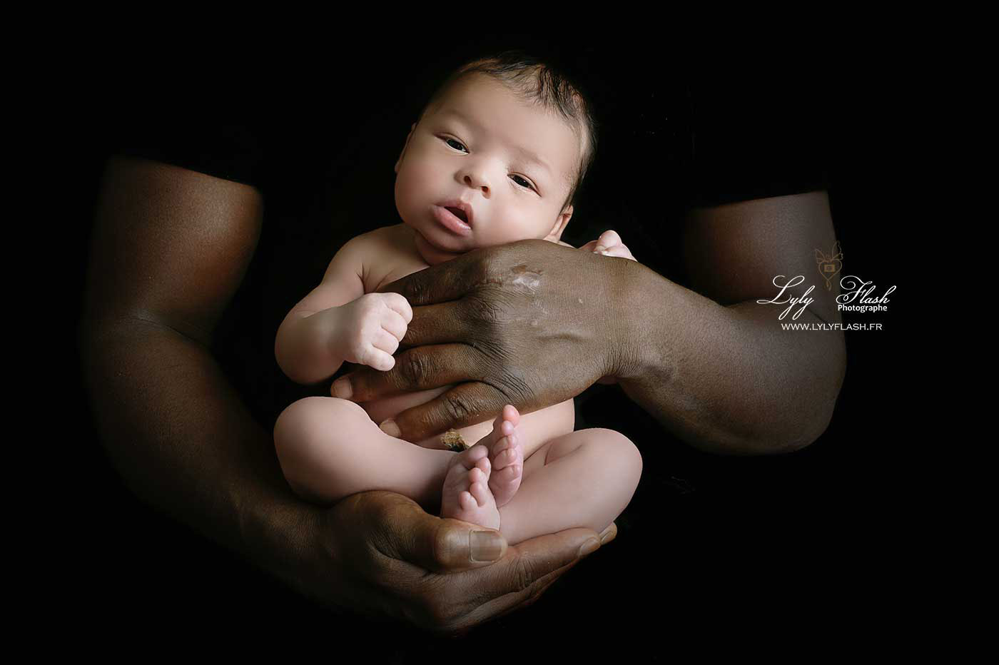 Sur cette photo touchante, un nouveau-né repose délicatement dans les mains protectrices de son papa d'origine africaine. La tendresse et la force s'unissent, mettant en lumière la connexion profonde entre parent et enfant. Les petites mains du bébé contrastent avec les mains robustes de son père, créant une image symbolisant l'amour, la protection et les premiers instants d'une nouvelle vie