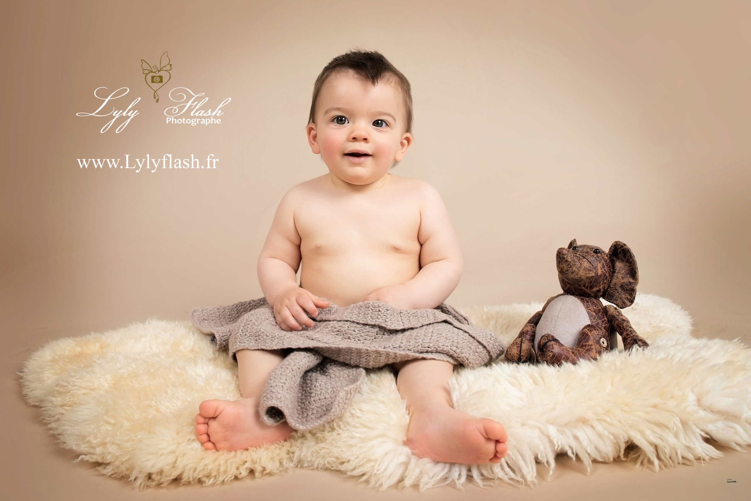 photo d un bébé de 9 mois en séance photo studio, il est trop mignon avec son petit éléphant