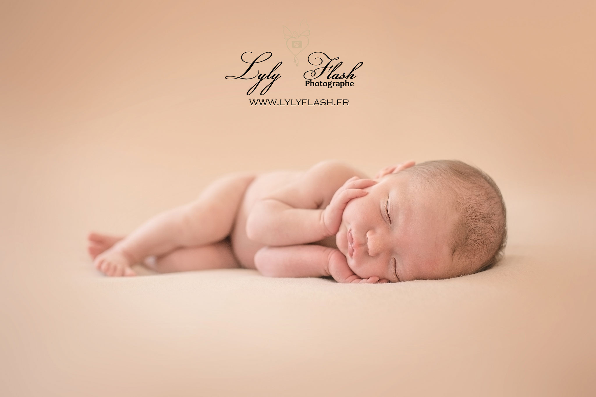 photographie poétique d'une petite fille a la naissance en studio photo. Ses mains sont posées délicatement sur son visage