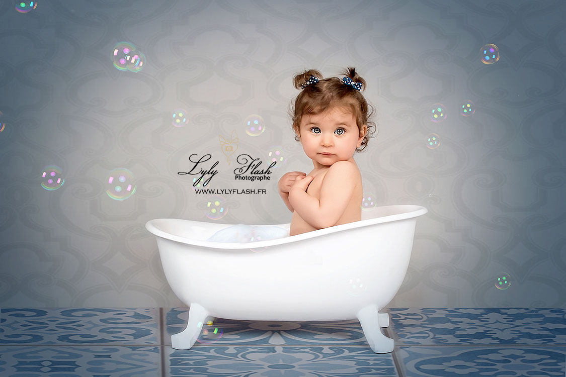 photographie d une petite fille de 2 ans qui prend un bain de mousse et de bulle