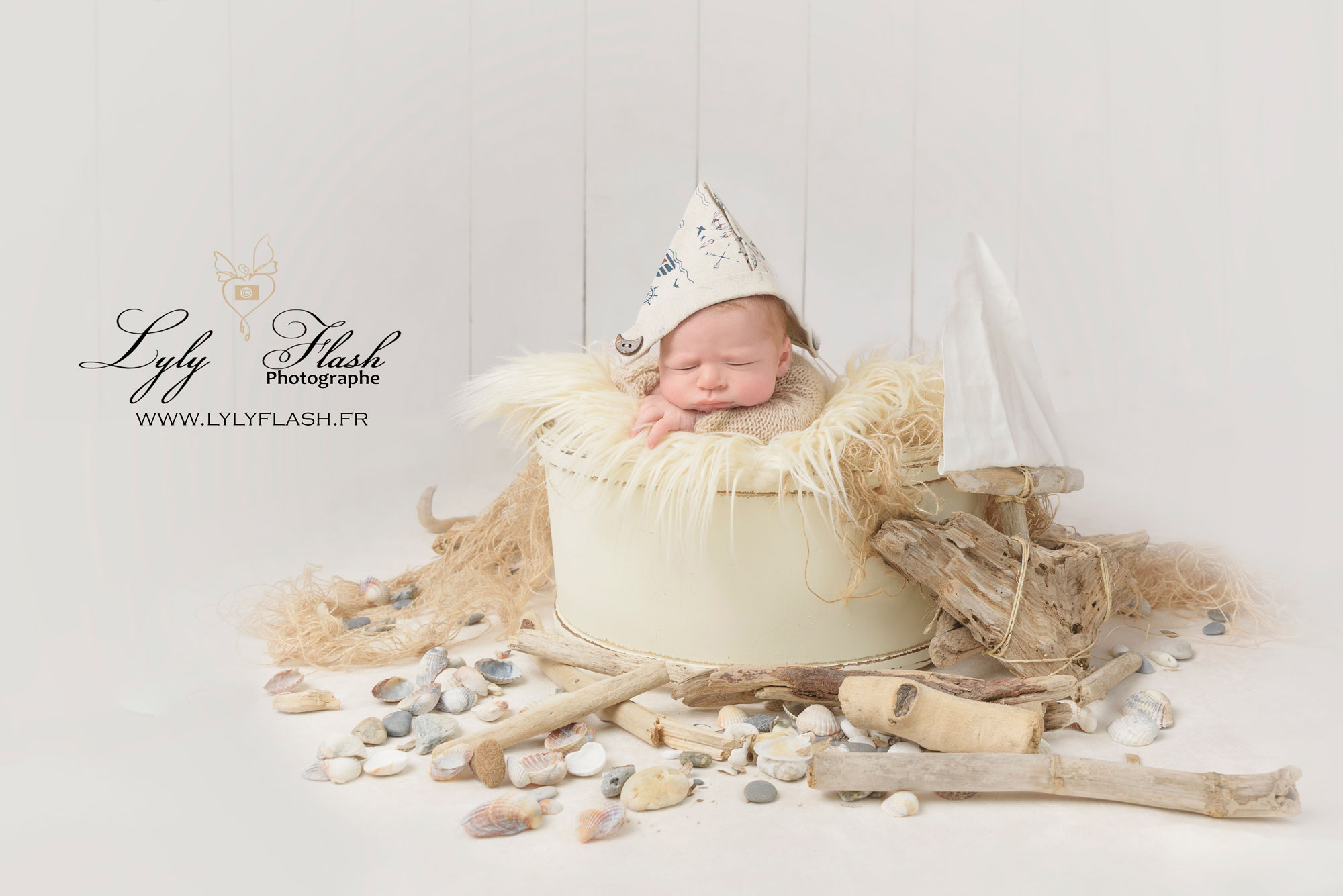 photo de naissance un bébé porte un chapeau de matelot en papier