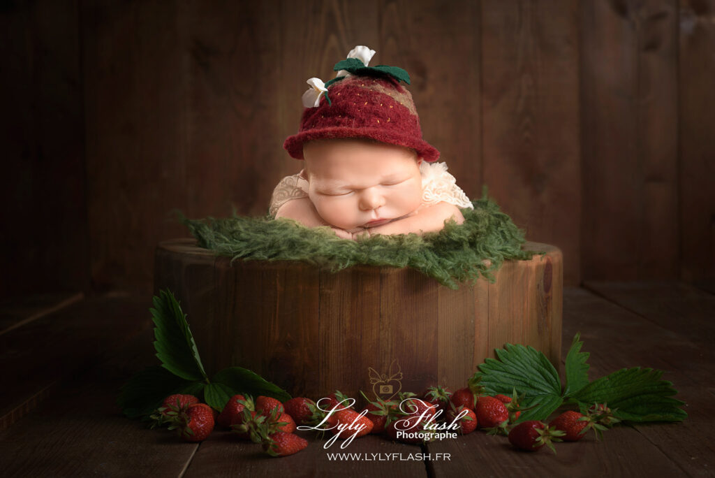 photo d'une petite fille de 5 jours qui dort sur un lit de fraise chez la photographe de brignoles