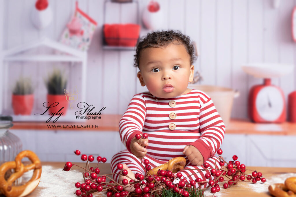 photo d un beau bébé métisse sur la table de noël sous l'œil de la photographe professionnel Lyly flash