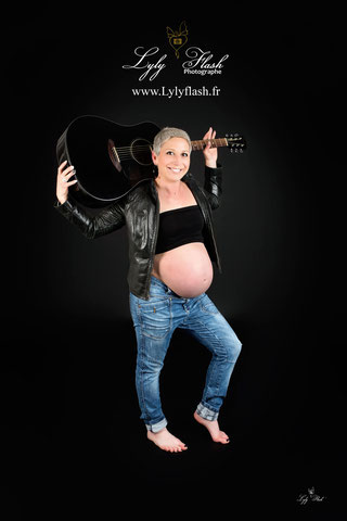 photo de grossesse d'une future maman très rock avec une veste en cuire et une guitare