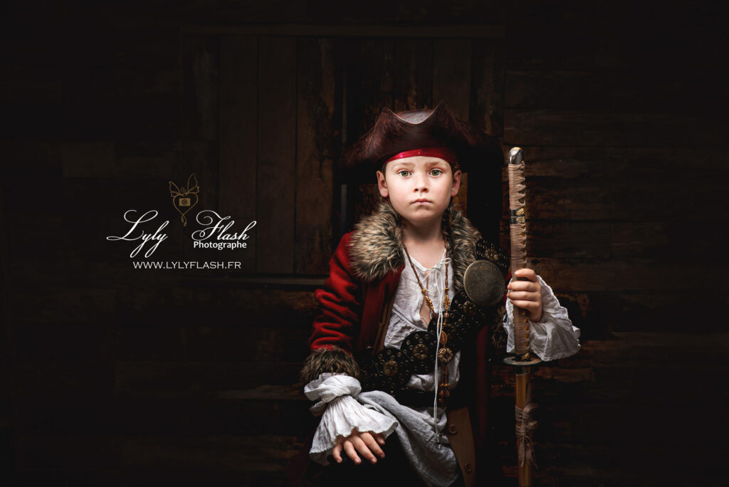 photo portrait de petit pirate en studio, son air triste et mis en valeur par l'éclairage de la photographe. Une photographie pleine d'émotion