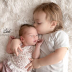 Un bisous d'un grand frère a un bébé à la naissance pour cette famille de Néoules, photographie réalisée en studio par la photographe Lyly flash