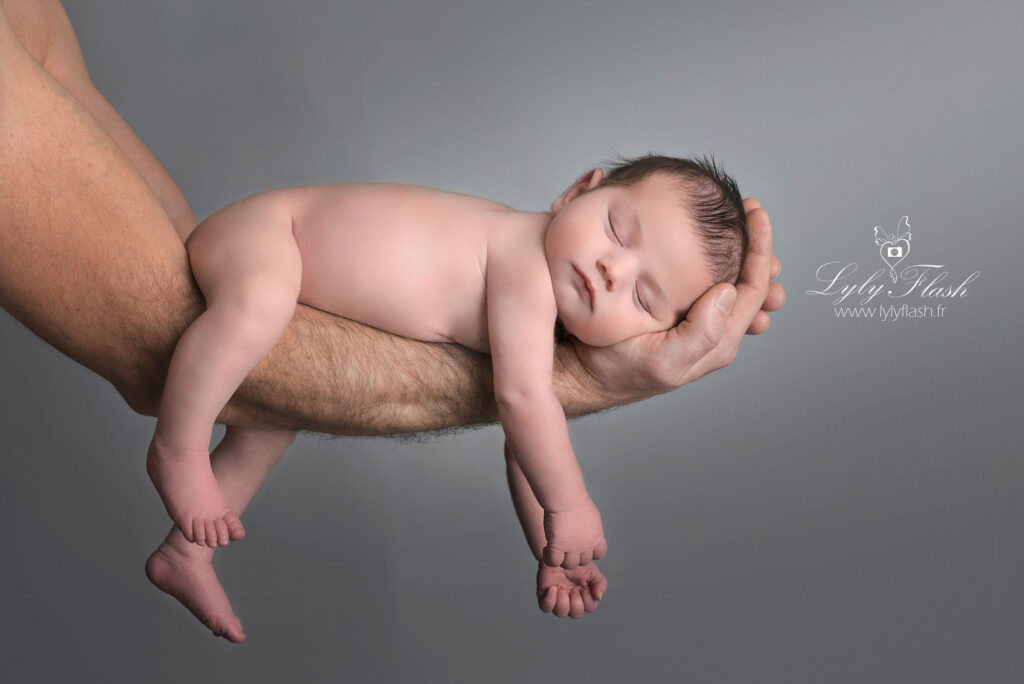 un nourrisson dort sur le bras de son papa une photographie poétique et pleine de douceur réalise en studio photo par la photographe de Tarascon