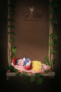 Petite fille à la naissance dort sur une balançoire. C'est une petite blanche neige, avec sa pomme rouge, elle est magnifique avec ses cheveux noir et ses joues rose. Quand on pense qu'elle est venue de Monaco pour ce délicieux cliché