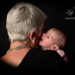 photo couleur a la naissance d un nouveau-né qui chuchote a l'oreille de sa maman, une photographie prise sur le vif en shooting photo qui démontre toute la réactivité de notre photographe qui s'assure un rendu exceptionnel de vos souvenir de naissance pour votre bébé et votre famille