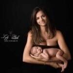 Une magnifique jeune maman de Cannes venue en shooting photo naissance avant son départ pour les Etats Unis tient son petit garçon nourrisson dans ses bras avec beaucoup de fierté. Une photographie réalise en studio par la photographe LylyFLash