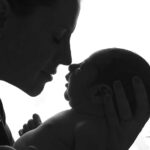 Photo en contre jour présentant le profil d une jeune maman avec son nouveau-né de quelques jours. Nez contre nez dans un moment de tendresse. Photographie réalisée par Lyly Flash près de Besse-sur-Issole dans le Var