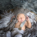 portrait d un bébé de Cavaillon pour sa naissance avec son bonnet son doudou et son contenant tous dans des teintes naturels