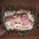 photo de naissance d'une petite fille avec son pantalon rose a dentelle , ce bébé venue de Cassis dort dans un lit de bois dans une atmosphère vintage