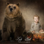 Un beau portrait de petit garçon de 18 mois, qui pose dans un beau contenant en bois, a coté d un bel ourson brun. Une photographie artistique pour mettre en valeur l'amour de cette famille pour la nature et le canada. Un petit clin d œil artistique qui a su leur faire plaisir