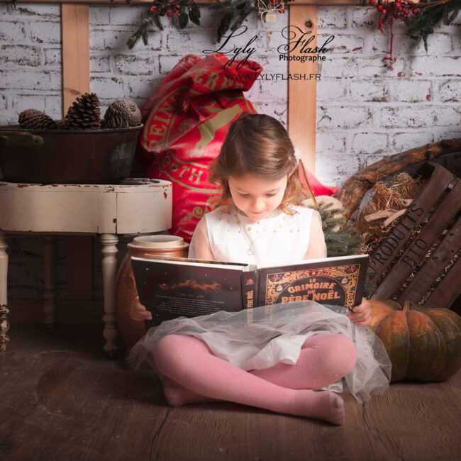 Une petite fille lit le livre de noël