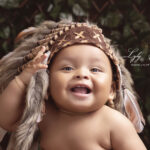 un beau bébé de brignoles qui pose avec une belle coiffe indienne et un sourire a faire fondre votre cœur. qu'il est beau ce bébé. C'est le genre de photographie que vous propose la photographe pour vos souvenirs de famille