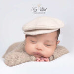 photo de naissance le beau bébé métisse porte une magnifique casquette une gavroche. Il est venu de Bargème pour son shooting naissance avec la photographe, photographie issu d'un shooting cocoon