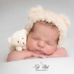 photo de naissance bébé avec un bonnet aux oreilles d'oursons et un doudou peluche. Le nouveau-né est venu de La Crau pour son shooting naissance