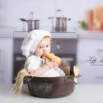 photo de bébé qui cuisine du pain, une photographie originale pour un bébé de 1 an en studio photo. Boulangerie Lafitau var