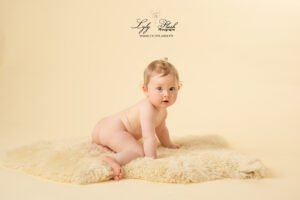 photo bébé 1 an en séance photo studio. Sur un fond jaune pour mettre en valeur sa chevelure blonde
